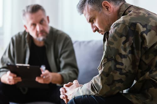 A veteran speaking with intake staff about veteran pain treatments at VeriSpine Joint Centers.